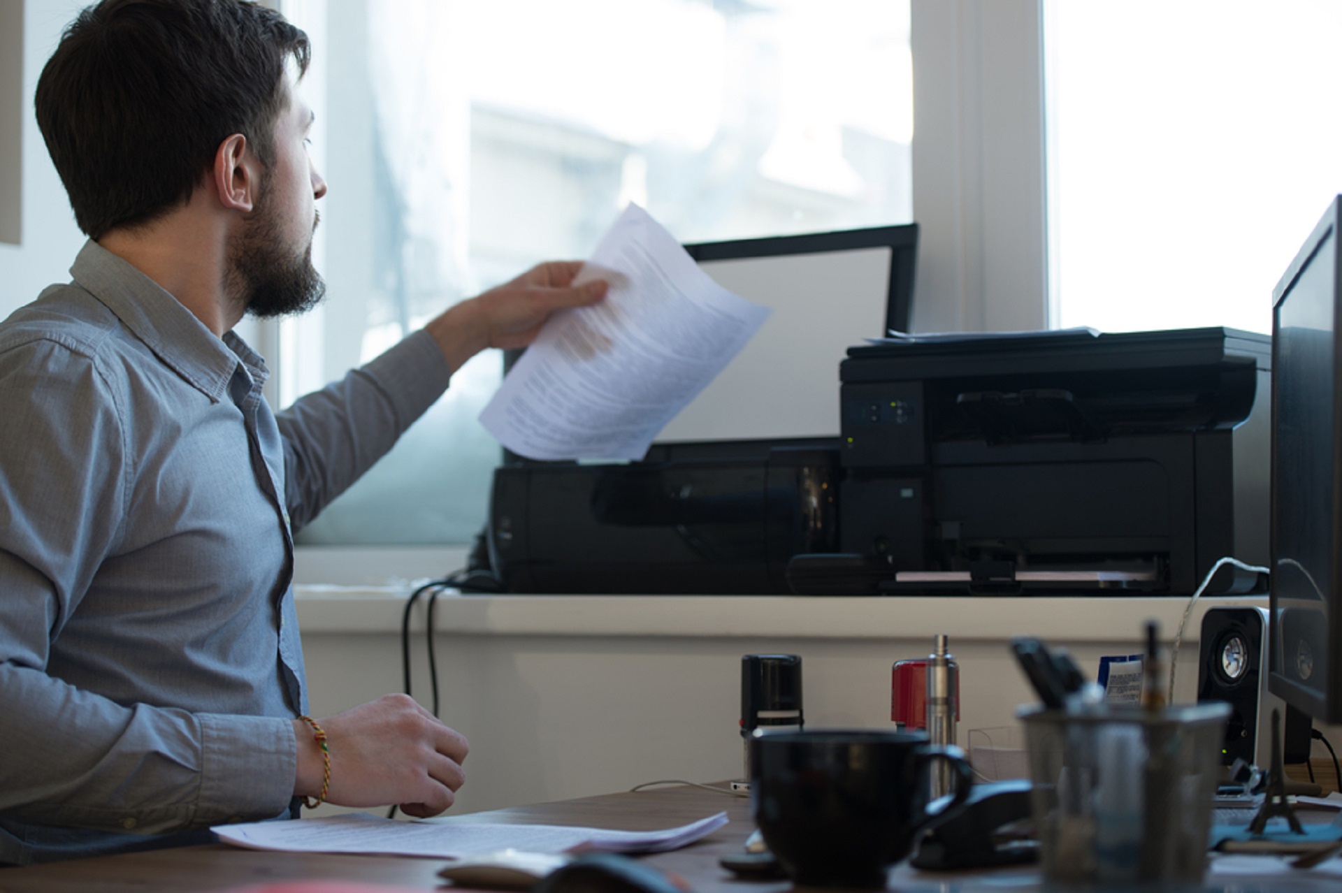 Mann scant eine Seite in einen Drucker ein 